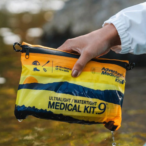 Person handing a medical kit in a river