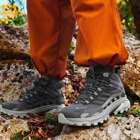 A person wearing hiking boots on a rock