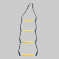 A vertical agility ladder with four yellow steps wrapped in black tape, suspended from a metal carabiner on a textured brown carpet.