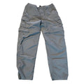 A pair of gray convertible pants laid flat on a beige carpeted floor.