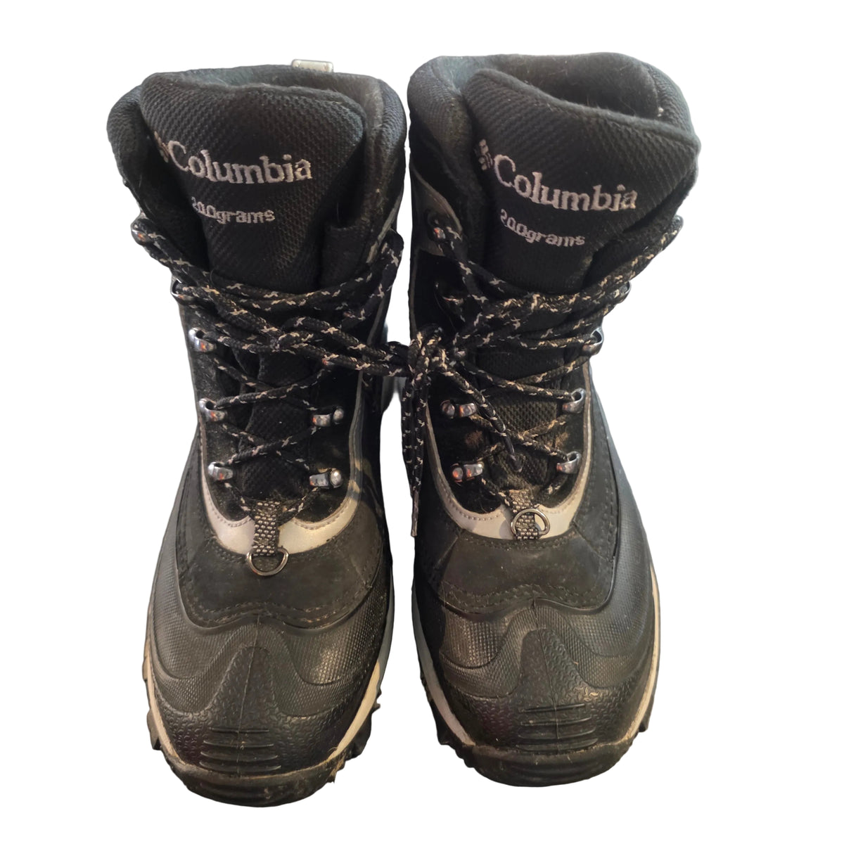 A pair of Columbia 900grams mid-calf hiking boots in black and gray, shown from the front on a dark gray floor.