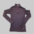 A dark heathered quarter-zip long-sleeve athletic top laid flat on a textured carpet. The garment has a mock neck, raglan sleeves, and a small white polo player logo near the bottom right hem.