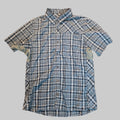 A short-sleeve button-up plaid shirt in blue, white, and gray, laid flat on a textured carpet.