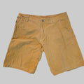 A pair of men's tan corduroy shorts laid flat on a gray carpeted floor.