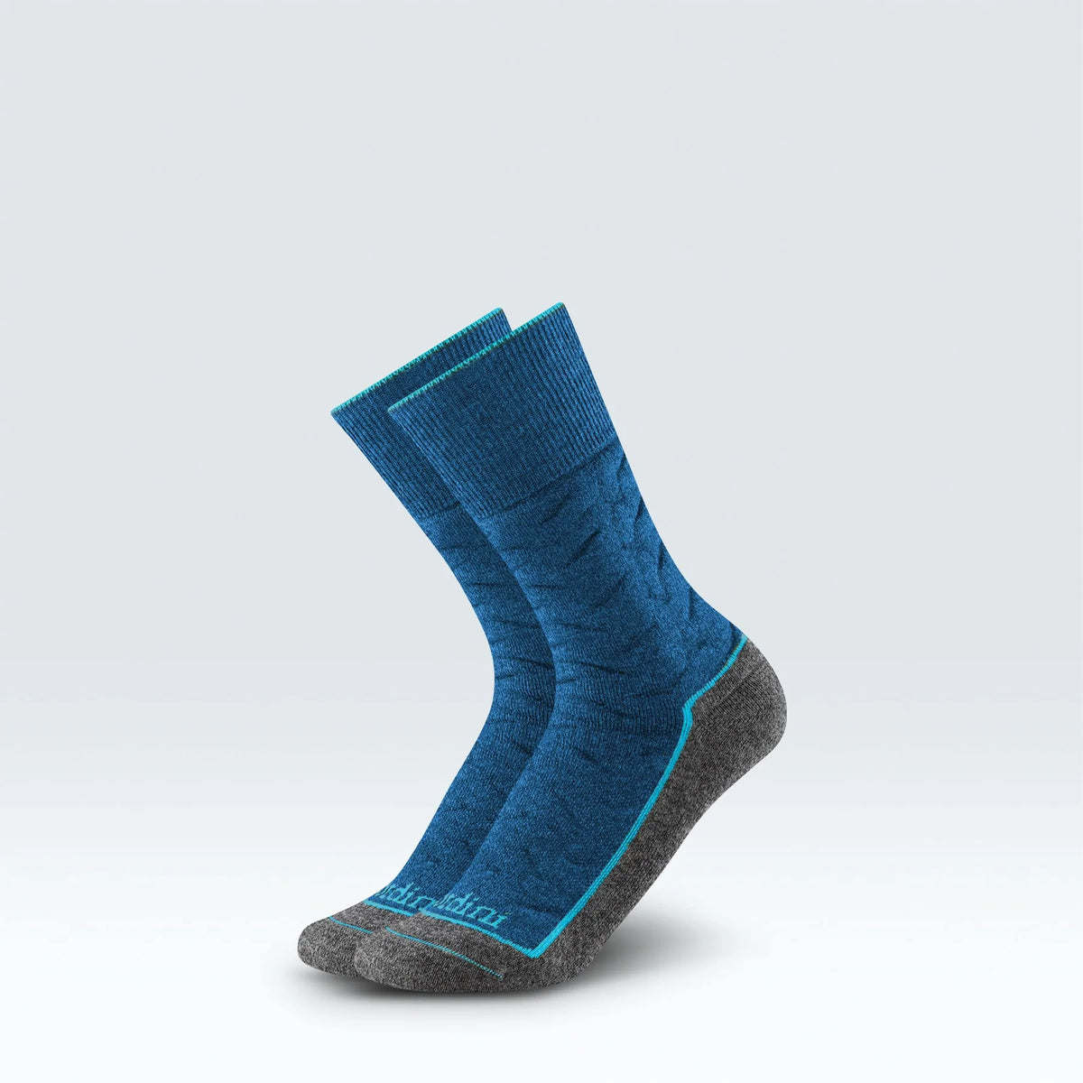 A pair of blue crew socks with gray toes and heels, featuring a thin turquoise accent line and the brand name 'Skechers' printed near the toe, set against a light gray gradient background.
