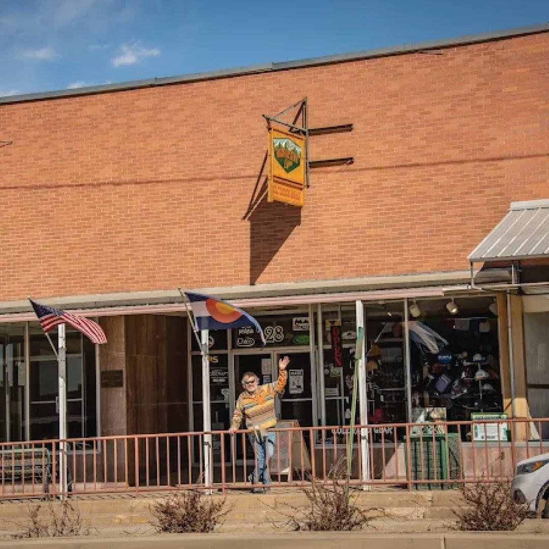 Jeff standing outside a brick building with a flag and sign on a clear day