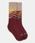 A pair of crew socks with a scenic mountain sunset pattern, featuring a beige top section with a yellow sun and multicolored ridges, and a burgundy lower section with the brand name 'KAKA' in white.