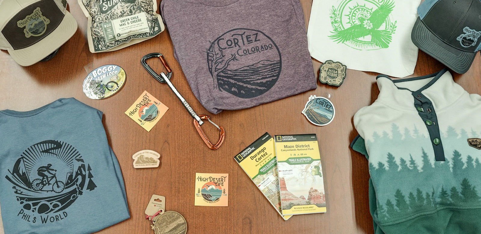 Collection of outdoor-themed clothing and accessories on a wooden surface