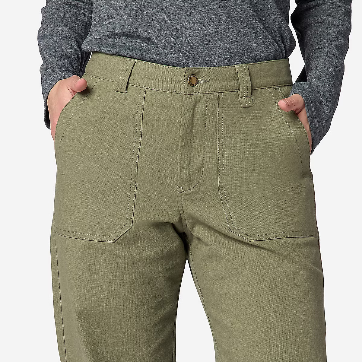 A close-up of a person wearing olive green cargo-style pants with a gray long-sleeve top, shown from the waist down against a light gray background.