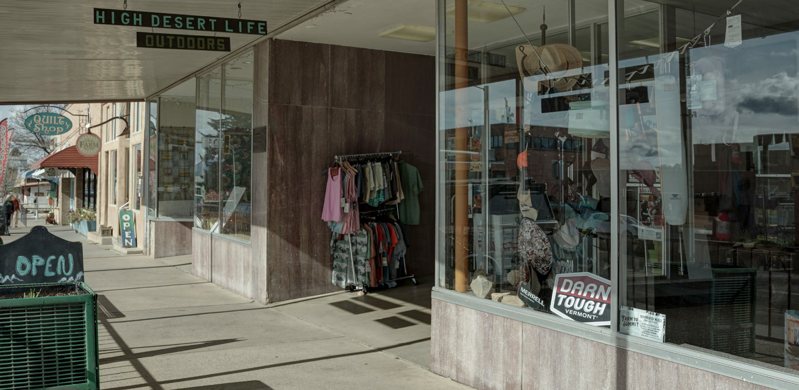 Storefront with clothing displayed outside on a city street
